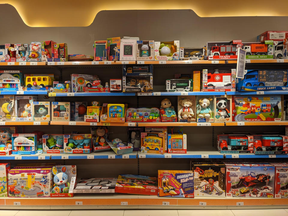 Store shelves filled with various children's toys, including toy cars, stuffed animals, puzzles, and educational toys