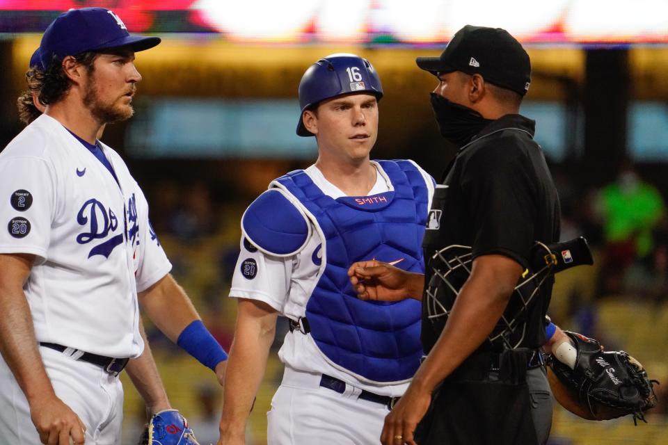 Dodgers pitcher Trevor Bauer and catcher Will Smith talk with umpire Edwin Moscoso.