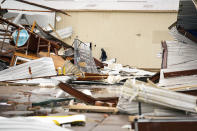 A man walks past destroyed buildings where a tornado was reported to pass along Mickey Gilley Blvd. near Fairmont Parkway, Tuesday, Jan. 24, 2023, in Pasadena, Texas. (Mark Mulligan/Houston Chronicle via AP)