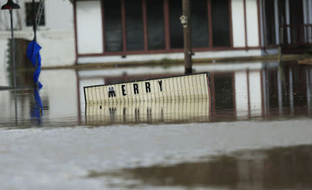 A sign sits underwater located in the downtown area of Elba, Alabama, December 26, 2015. REUTERS/Marvin Gentry