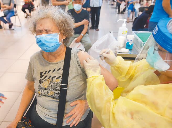 台北市環南市場群聚及虎林街周邊市場連續爆出疫情，新北市三重小巨蛋湧現施打莫德納疫苗人潮，老太太注射時痛得皺起眉頭。（本報資料照片）