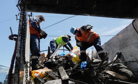 People clean debris from the streets in the aftermath of the last days' protests in Quito