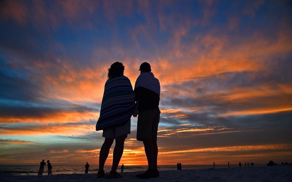 On vacation from Ohio, Bruce and Mary Anne Acer share a laugh together at sunset after renewing their marriage vows Feb. 14, 2019, on Siesta Key Beach.