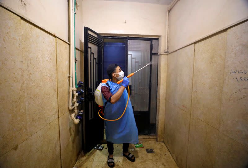 FILE PHOTO: A volunteer of a medical team sprays disinfectant in a house as a precaution to contain the spread of the coronavirus disease (COVID-19) at Shubra El Kheima in Al Qalyubia