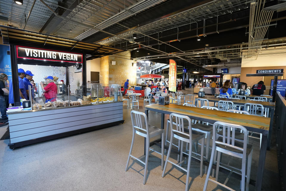 A general view of the Visiting Vegan food stand is shown at Globe Life Field before a spring training baseball game between the Texas Rangers and the Boston Red Sox, Monday, March 25, 2024, in Arlington, Texas. Most parks and arenas have a handful of areas that offer salads, gluten free or vegan offerings if fans are willing to hunt a little. But the vast majority of people attending baseball games aren't necessarily looking to eat healthy. (AP Photo/Sam Hodde)