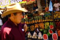 Employees work at a stall in an outdoor market dedicated to the sale of fruits and vegetables, in Ciudad Juarez