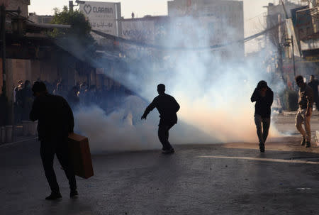 Kurdish protesters run away from tear gas during a rally against the Kurdistan Regional Government (KRG) in Sulaimaniyah, Iraq December 18, 2017. REUTERS/Stringer