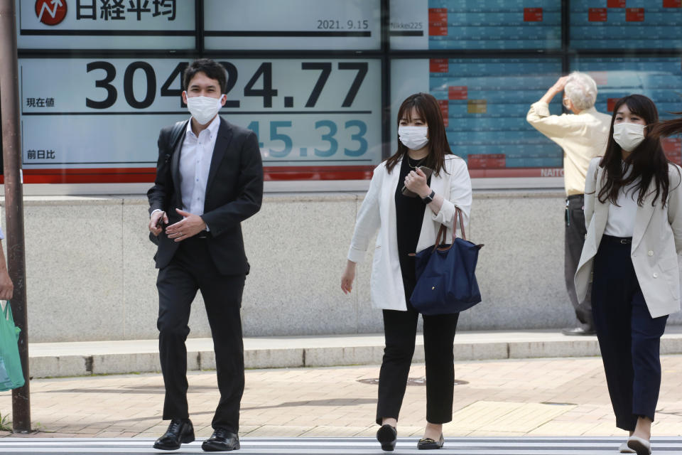 People walk by an electronic stock board of a securities firm in Tokyo, Wednesday, Sept. 15, 2021. Asian stock markets followed Wall Street down on Wednesday after U.S. inflation was lower than expected amid unease about the impact of the spread of the coronavirus's delta variant. (AP Photo/Koji Sasahara)