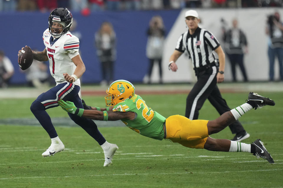 Liberty quarterback Kaidon Salter (7) eludes Oregon linebacker Devon Jackson during the second half on the NCAA Fiesta Bowl college football game, Monday, Jan. 1, 2024, in Glendale, Ariz. Oregon defeated Liberty 45-6. (AP Photo/Ross D. Franklin)