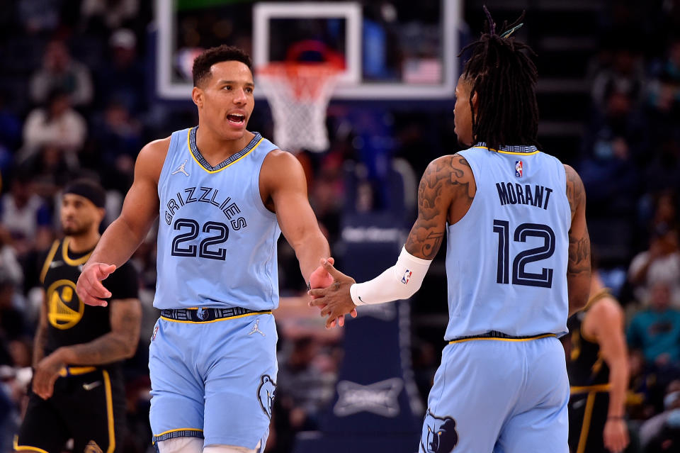 Desmond Bane of the Memphis Grizzlies and Ja Morant slap hands during a game.