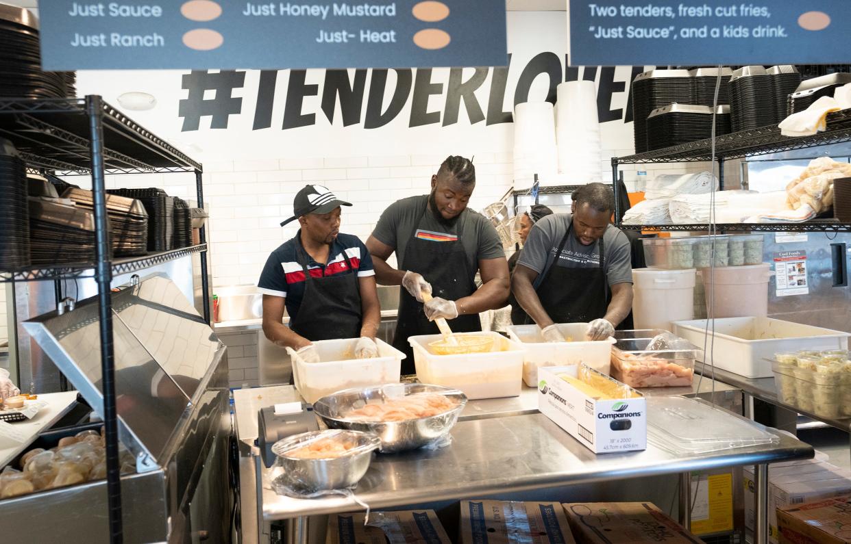 Apr 13, 2023; New Albany, Ohio, USA; (from L) Johnny Gulles, Mackemsyn Pierre and Icard Pierre prepare chicken in the Just Chicken location inside of Bubbly Hall. Mandatory Credit: Brooke LaValley/Columbus Dispatch