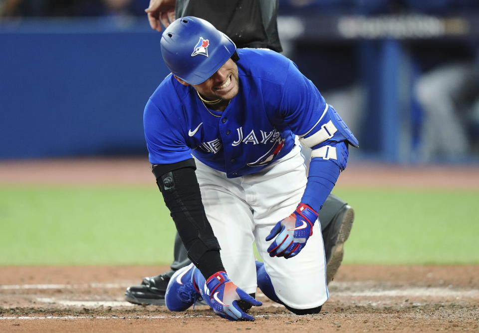 Toronto Blue Jays' George Springer reacts after being hit by a pitch from Seattle Mariners' Luis Castillo during the eighth inning of Game 1 of a baseball AL wild-card series, Friday, Oct. 7, 2022, in Toronto. (Nathan Denette/The Canadian Press via AP)