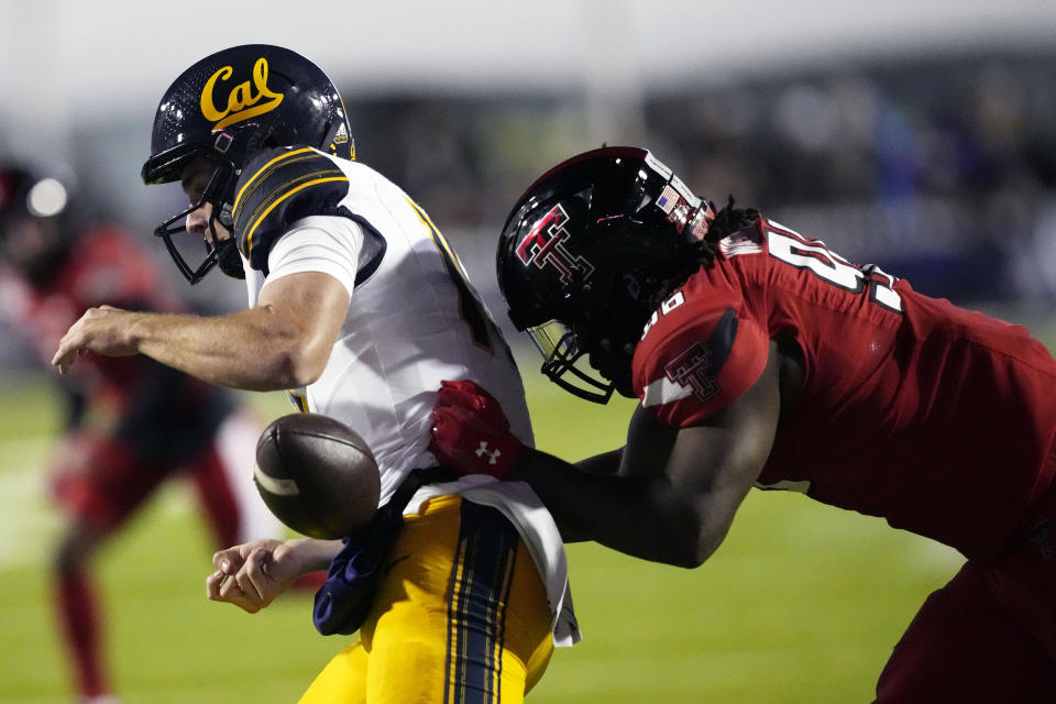 California quarterback Fernando Mendoza (15) has the ball stripped from him by Texas Tech defensive lineman Amier Washington (96) during the first half of the Independence Bowl NCAA college football game Saturday, Dec. 16, 2023, in Shreveport, La. (AP Photo/Rogelio V. Solis)