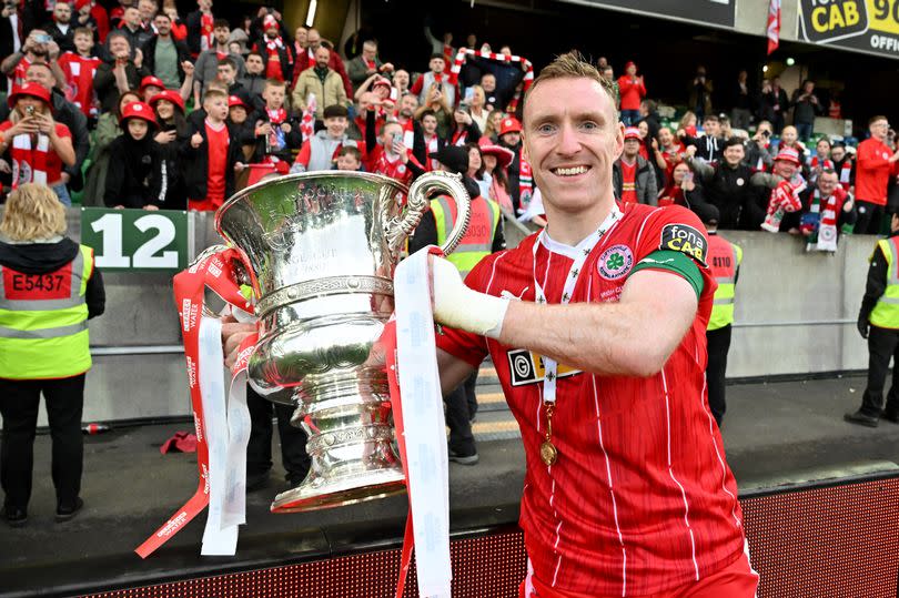 A picture of Cliftonville’s Chris Curran celebrating with the Irish Cup