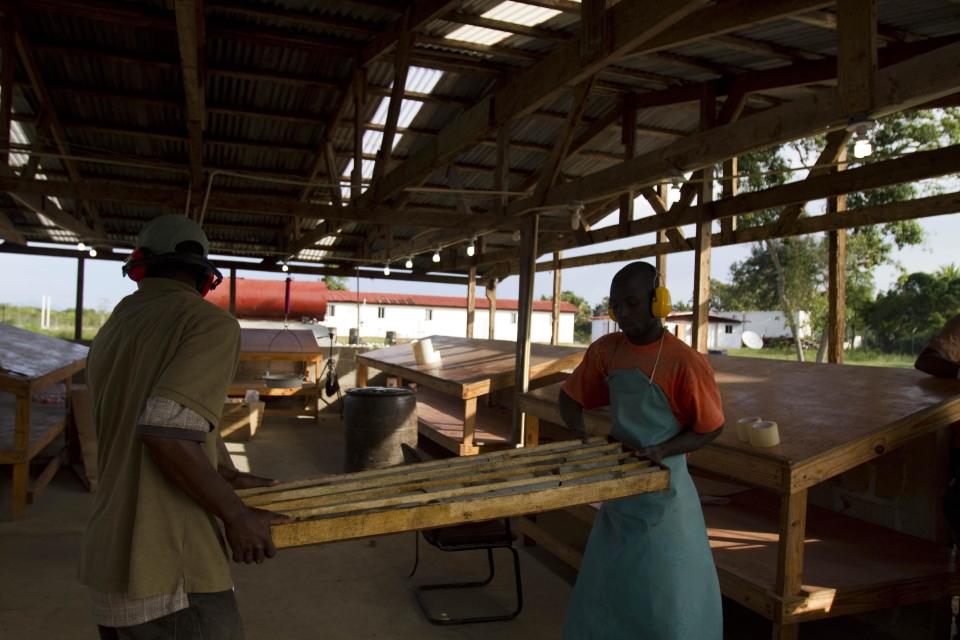 In this April 10, 2012 photo, workers load samples of rock drilled from the mountains to a mobile laboratory where they will be examined by geologists for minerals and metals as part of the SOMINE mine exploration camp in the department of Trou Du Nord, Haiti. Haiti's land may yet hold the solution to centuries of poverty: there is gold hidden in its hills, and silver and copper too. Now, two mining companies are drilling around the clock to determine how to get those metals out, and how much it might cost. (AP Photo/Dieu Nalio Chery)