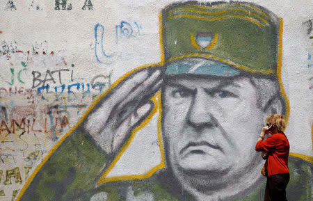 A woman walks past graffiti of Bosnian Serb wartime general Ratko Mladic in a suburb of Belgrade, Serbia, May 27, 2011. REUTERS/Stoyan Nenov/File Photo