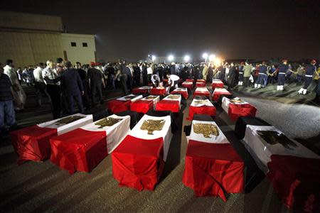 The caskets of 25 policemen killed in an ambush by Islamist militants near the north Sinai town of Rafah lie on the ground after arriving at Almaza military airport in Cairo in this August 19, 2013 file photo. REUTERS/Mohamed Abd El Ghany/Files