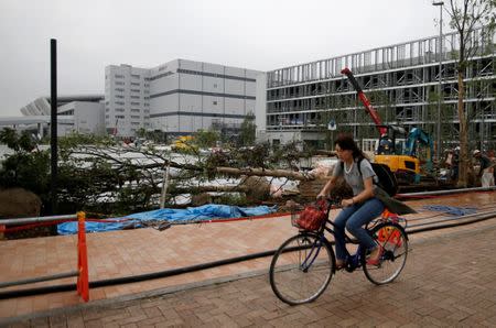 A woman cycles past the new Tokyo Metropolitan Central Wholesale Market, known as Toyosu market, which will take over from the famous Tsukiji market, under construction in the Toyosu district in Tokyo, Japan, September 27, 2016. REUTERS/Toru Hanai