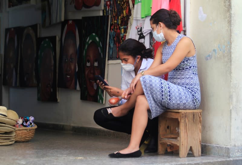 Shop assistants wear protective face masks after Cuba confirmed its first cases of the new coronavirus (COVID-19), in Havana