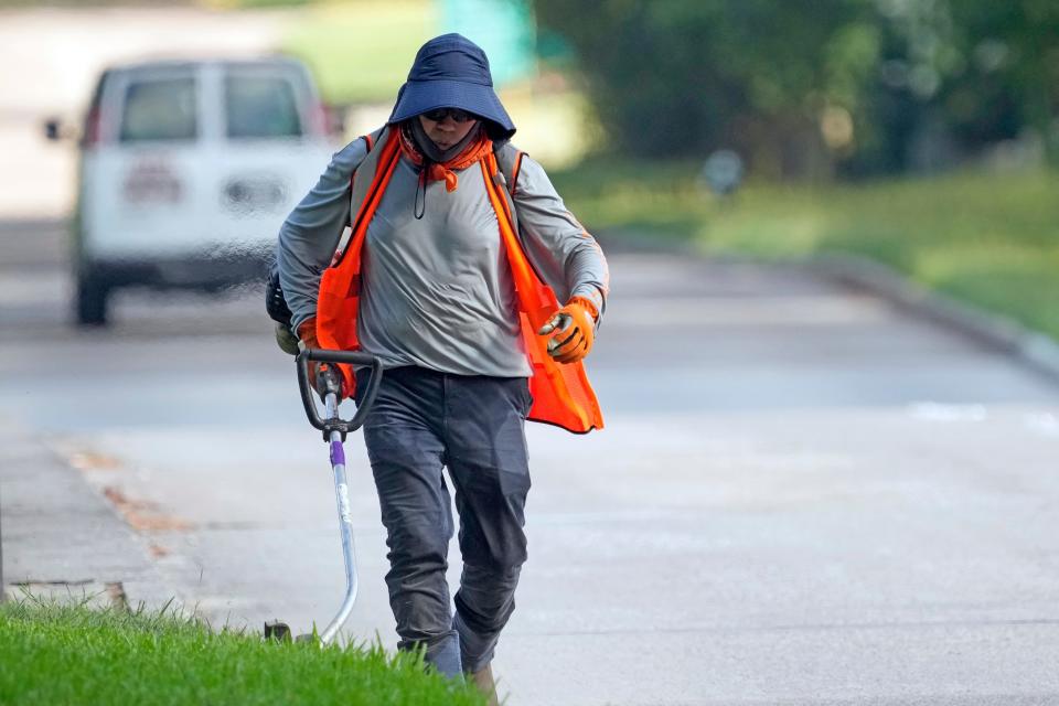 Salvador Alfredo wears protective clothing as he works outside Tuesday, June 27, 2023, in Houston.