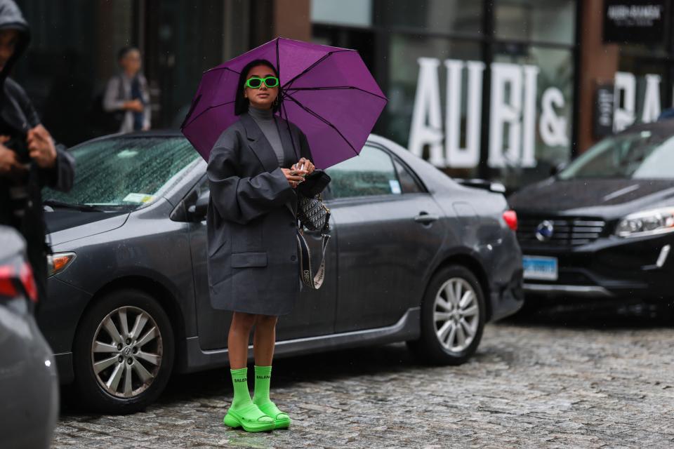 Eine Besucherin der New York Fashion Week mit Schuhen von grünen Crocs, die in Zusammenarbeit mit dem Modelabel Balenciaga entstanden sind. - Copyright: eremy Moeller/Getty Images