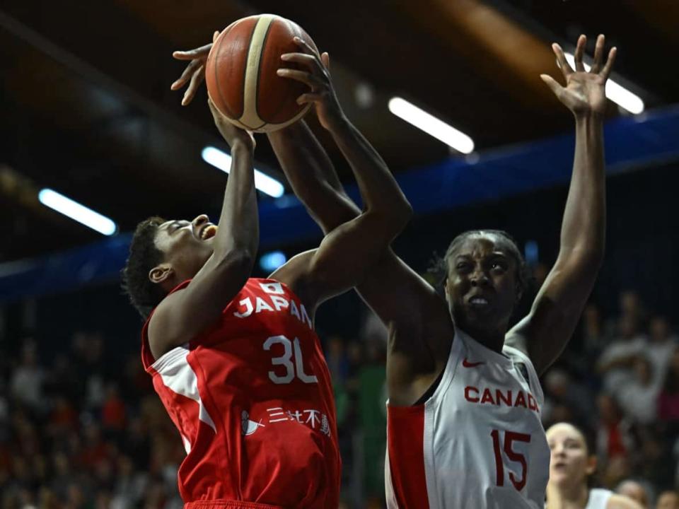 Japan's Evelyn Mawuli (left) and Canada's Laeticia Amihere (right) vie for the ball during the 2024 FIBA Women's Olympic qualifying tournament basketball match in Sopron, Hungary on Sunday. (Attila Kisbenedek/Getty Images - image credit)