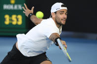 Matteo Berrettini of Italy plays a backhand return to Carlos Alcaraz of Spain during their third round match at the Australian Open tennis championships in Melbourne, Australia, Friday, Jan. 21, 2022. (AP Photo/Andy Brownbill)