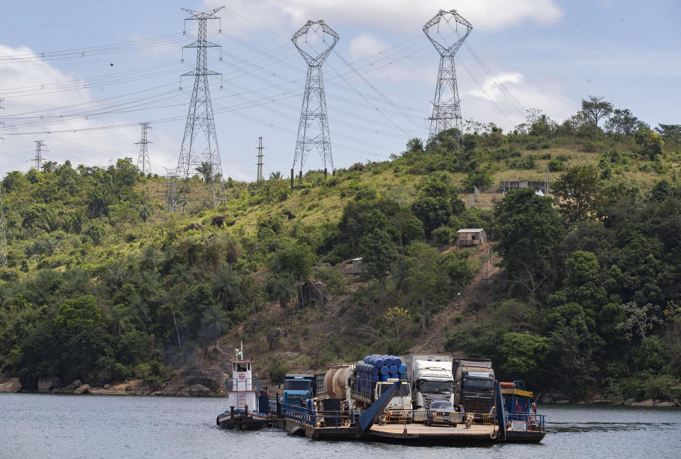 Un transbordador lleva grandes camiones por el río Xingu, cerca de la presa hidroeléctirca de Belo Monte, en Altamira, en el estado brasileño de Para, el viernes 6 de septiembre de 2019. (AP Foto/Andre Penner)