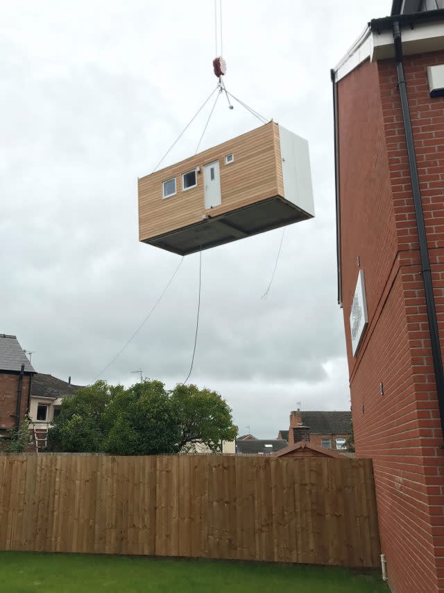 A micro-home is lifted into place