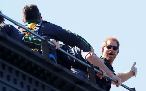 Prince Harry gives a thumbs-up as he climbs the Sydney Harbour Bridge - Credit: RICK STEVENS /Reuters