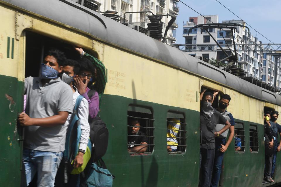 Passengers wearing facemasks amid concerns over the spread of the COVID-19 novel coronavirus, travel in a train at the Bidhan Nagar Road railway station, in Kolkata on March 21, 2020. (Photo by Dibyangshu SARKAR / AFP) (Photo by DIBYANGSHU SARKAR/AFP via Getty Images)