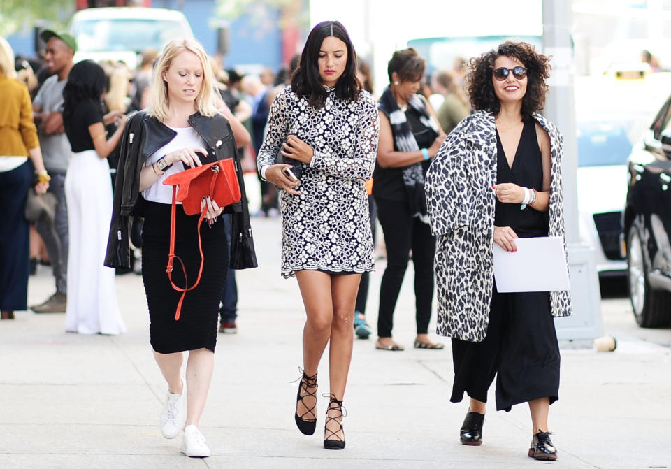 Three fashion show goers in black and white outfits at New York Fashion Week.