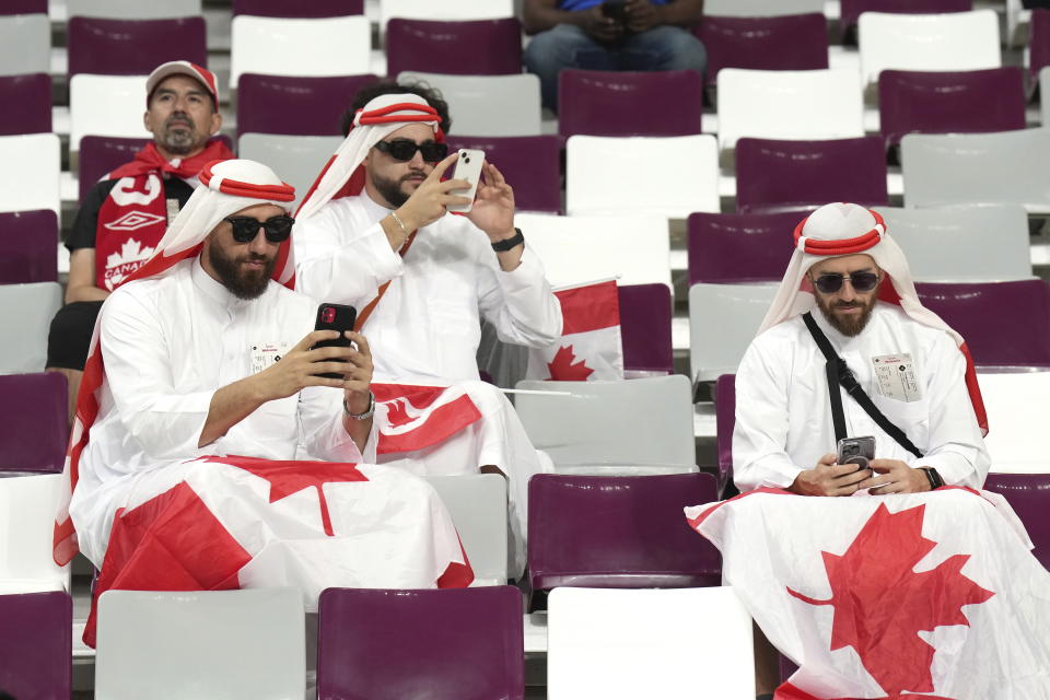 FILE - Canadian fans cheer ahead of F World Cup soccer action between Canada and Croatia at the Khalifa International Stadium in Al Rayyan, Qatar on Sunday, Nov. 27, 2022. At a World Cup that has become a political lightning rod, it comes as no surprise that soccer fans’ sartorial style has sparked controversy. At the first World Cup in the Middle East, fans from around the world have refashioned traditional Gulf Arab headdresses and thobes. (Nathan Denette/The Canadian Press via AP, File)