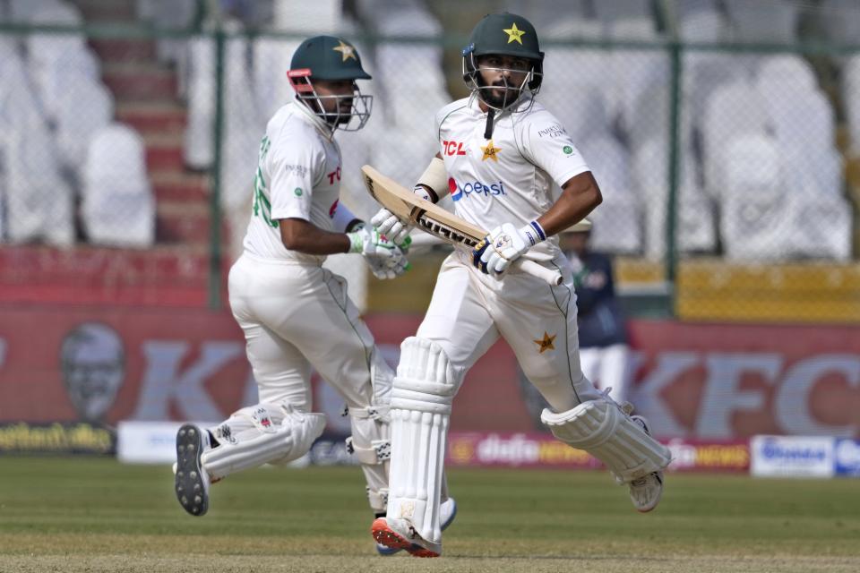 Pakistan's Saud Shakeel, right, and Babar Azam run between the wickets during the third day of third test cricket match between England and Pakistan, in Karachi, Pakistan, Monday, Dec. 19, 2022. (AP Photo/Fareed Khan)