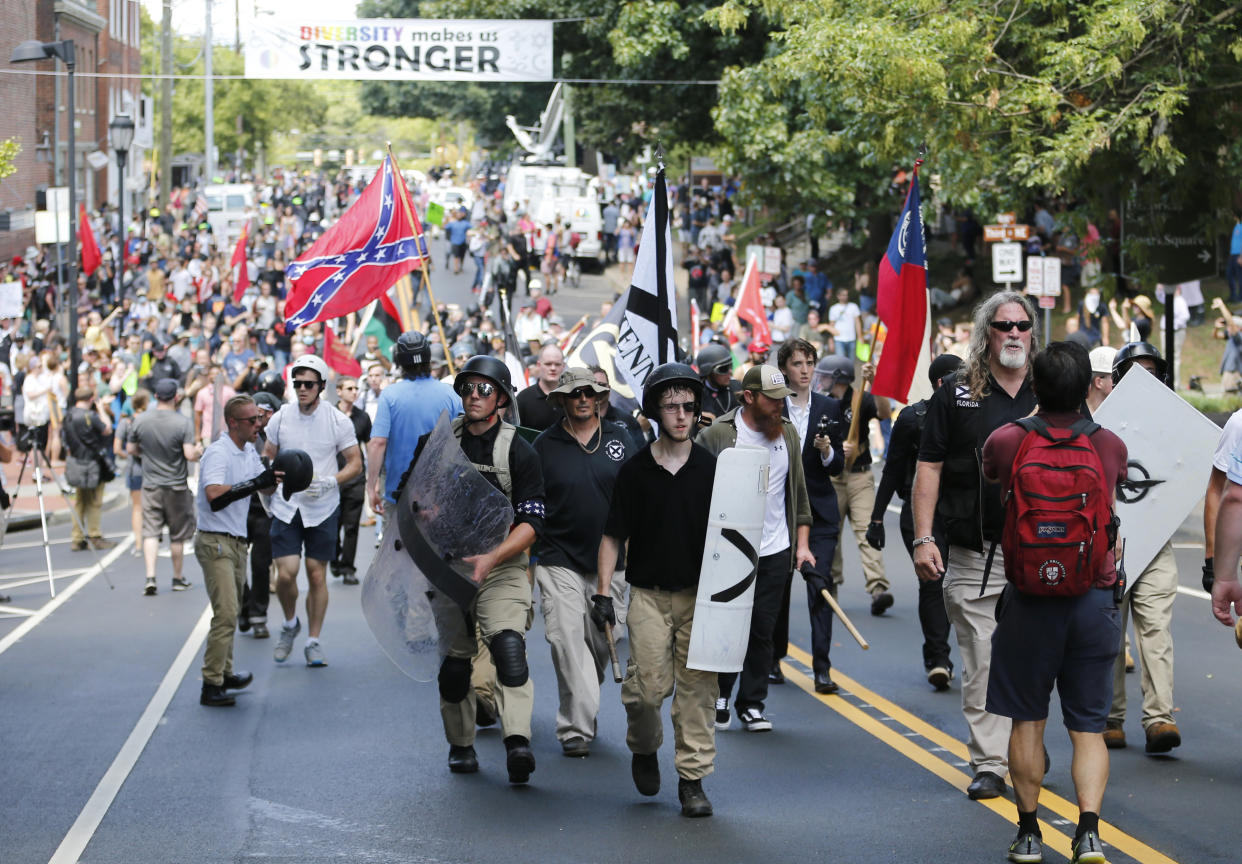 White nationalist demonstrators walk through town after their rally was declared illegal near Lee Park in Charlottesville, Va., Saturday, Aug. 12, 2017. (AP Photo/Steve Helber)