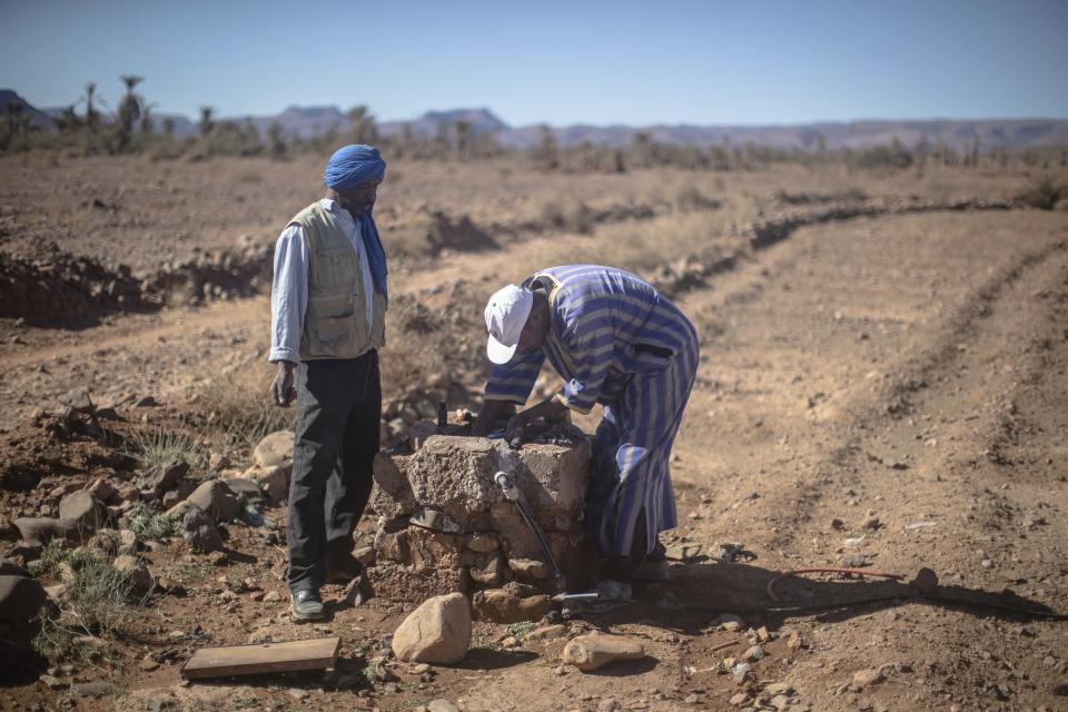 Farmers attempt to collect water from a well to water their lands in the in the Nkob town, near Zagora, Morocco, Monday, Nov. 28, 2022. (AP Photo/Mosa'ab Elshamy)