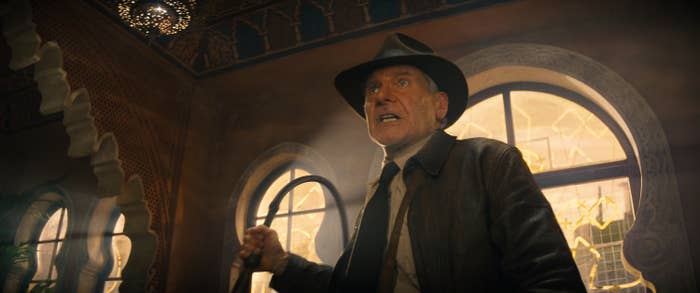 Harrison Ford as Indiana Jones holding his famous whip and wearing the iconic fedora in a scene from Indiana Jones and the Dial of Destiny