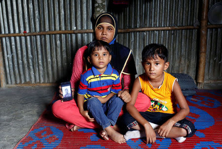 Noor Ankis, 25, whose husband Ayub, a leader of the unregistered makeshift camp in Kutupalong, was killed late last month, poses for a picture with her two children in Cox’s Bazar, Bangladesh, July 9, 2017. REUTERS/Mohammad Ponir Hossain