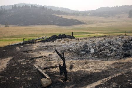 Hay and farm equipment burned by the Okanogan Complex fire are seen near Tonasket, Washington August 25, 2015. REUTERS/David Ryder