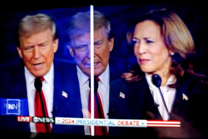 Donald Trump and Kamala Harris are shown on screen in the spin room during the second presidential debate