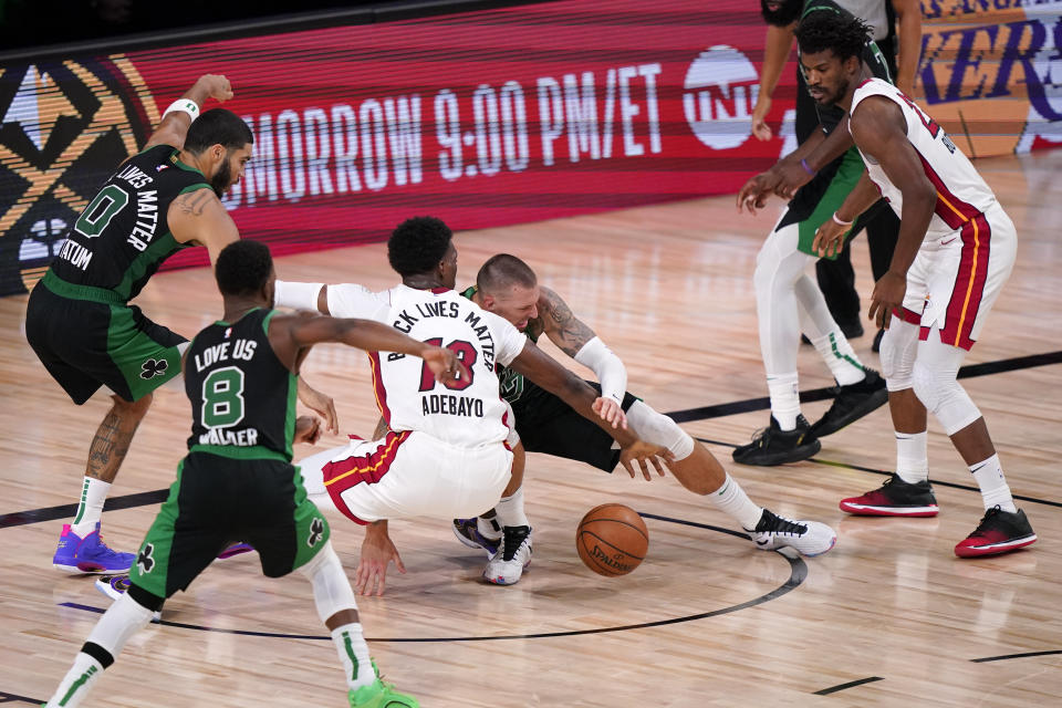 Miami Heat's Bam Adebayo (13) and Boston Celtics' Daniel Theis (27) battle for the ball during the second half of an NBA conference final playoff basketball game Friday, Sept. 25, 2020, in Lake Buena Vista, Fla. The Celtics won 121-108. (AP Photo/Mark J. Terrill)