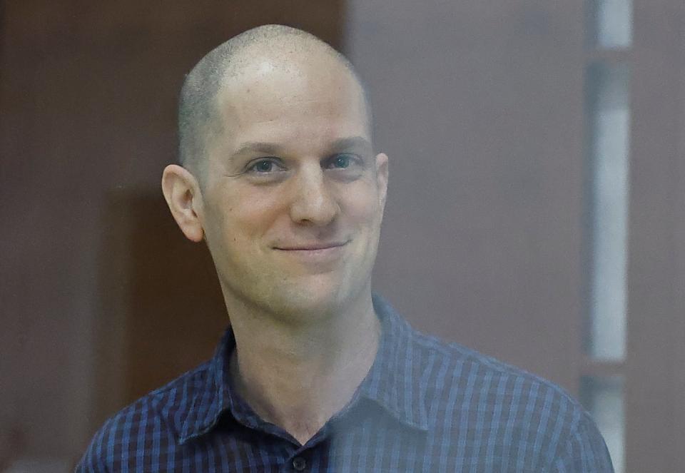 Wall Street Journal reporter Evan Gershkovich, who stands trial on spying charges, smiles inside an enclosure for defendants before a court hearing (REUTERS)