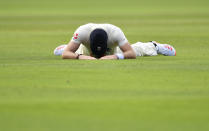 England's James Anderson reacts as he lies on the ground after failing to stop the ball during the third day of the first cricket Test match between England and Pakistan at Old Trafford in Manchester, England, Friday, Aug. 7, 2020. (Dan Mullan/Pool via AP)