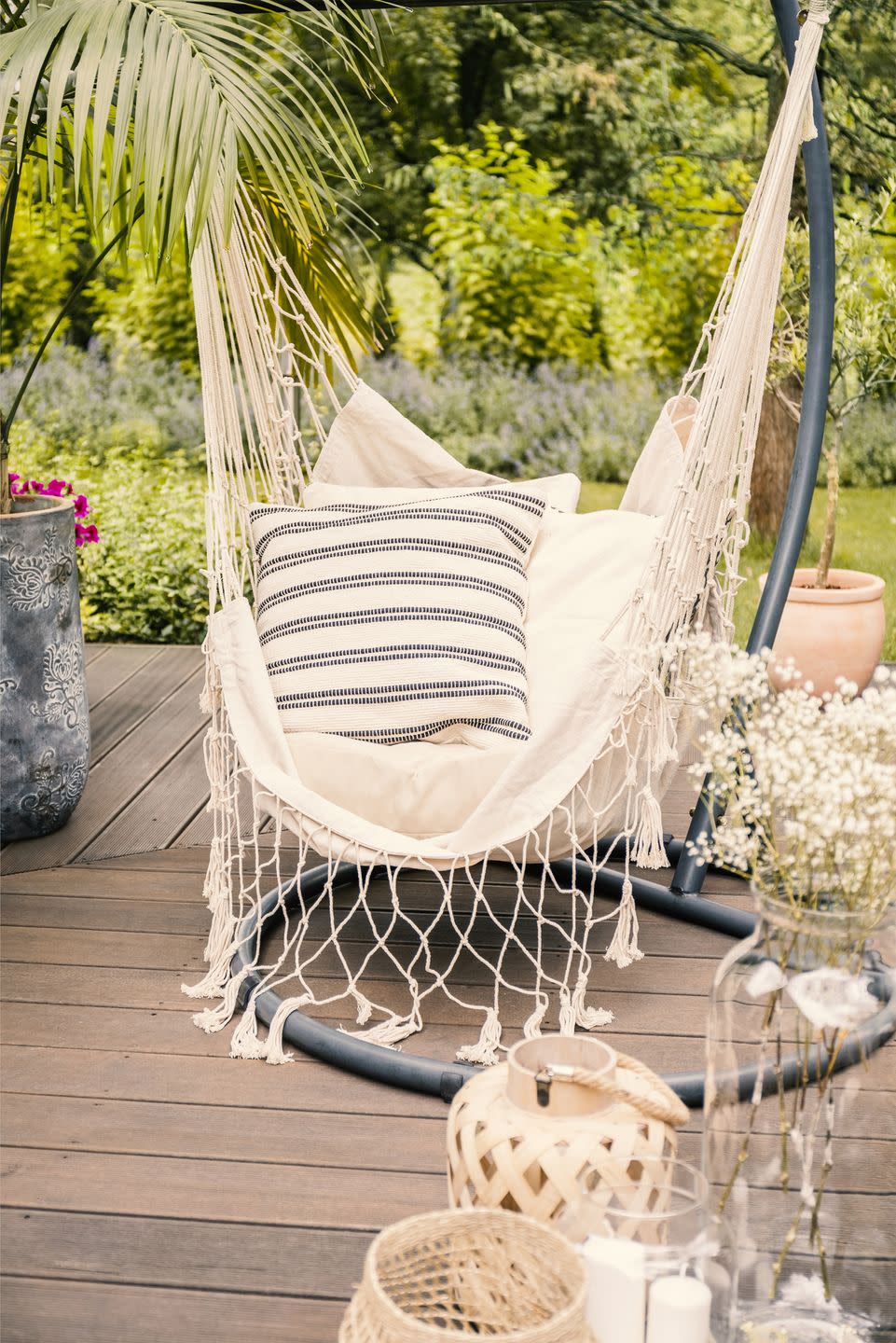 close up of a string hammock with cushions on a deck in a yard