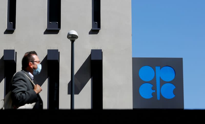 FILE PHOTO: A person passes the OPEC logo in front of its headquarters in Vienna