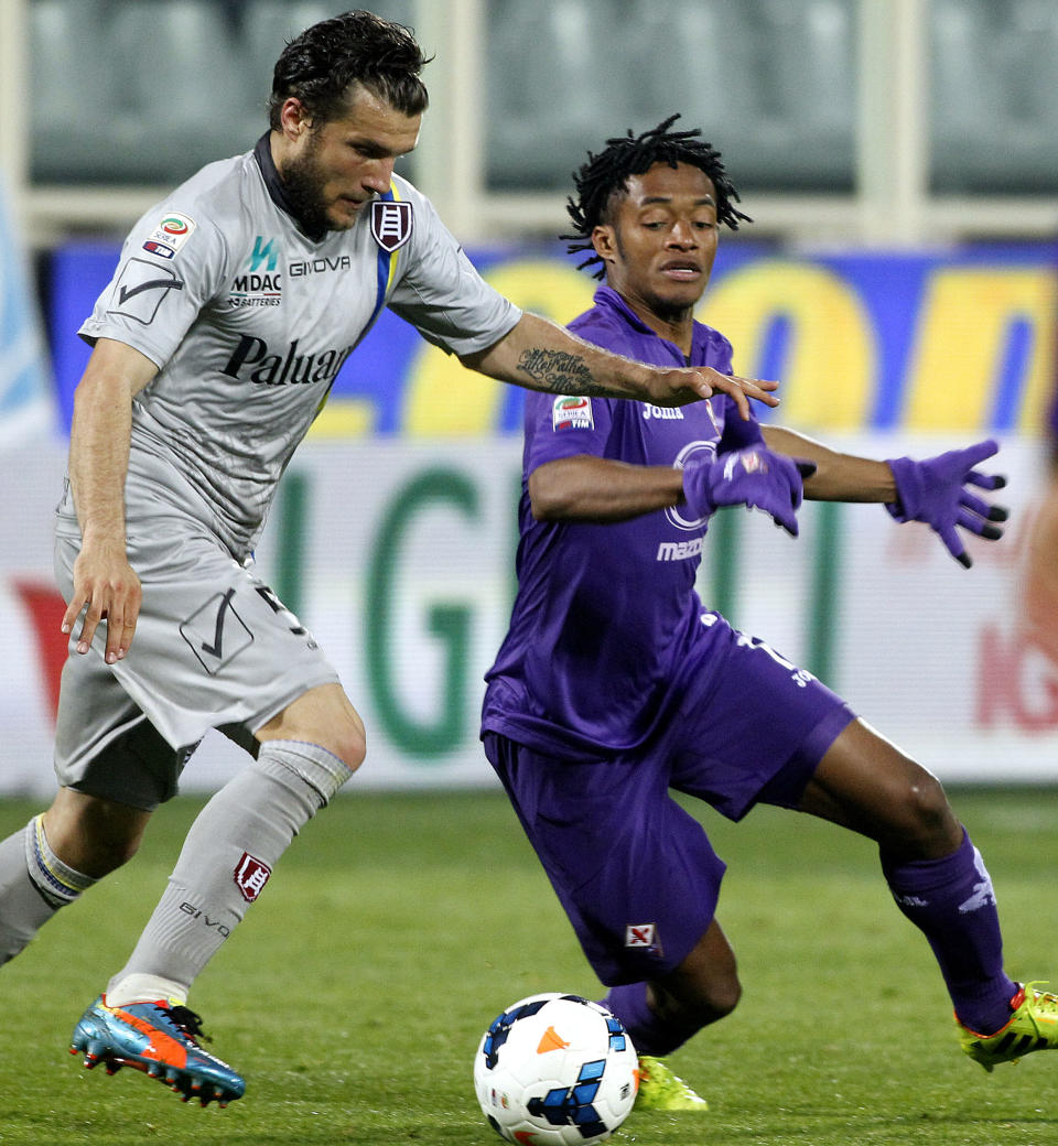 Fiorentina's Juan Cuadrado, right, is challenged by Chievo's Perparim Hetemaj during a Serie A soccer match between Fiorentina and Chievo Verona, at the Artemio Franchi stadium in Florence, Italy, Sunday March 16, 2014. (AP Photo/Fabrizio Giovannozzi)