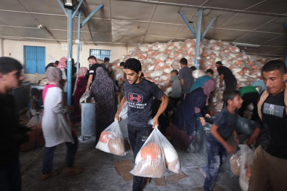 Palestinians raid a UN-run aid supply centre that distributes food to displaced families (AFP)