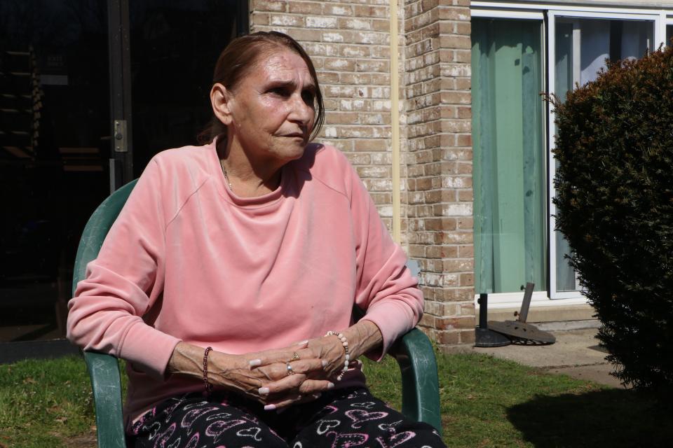 Donna Velino watches from the lawn outside her University Heights Apartments unit as Twentieth Century Studios films "Ella McCay" Tuesday afternoon.