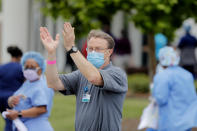 Human resources director Brion Stanford applauds at the conclusion of a jazz serenade for healthcare workers at New Orleans East Hospital, as a tribute for their care of COVID-19 patients, outside the hospital in New Orleans, Friday, May 15, 2020. A New York woman collaborated with the New Orleans Jazz Orchestra to put on what she calls a stimulus serenade to give moral support to front-line hospital workers and COVID-19 patients in New Orleans. (AP Photo/Gerald Herbert)