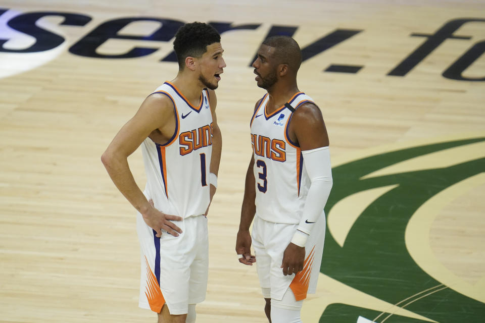 Phoenix Suns' Chris Paul (3) talks with Devin Booker (1) during the first half of Game 3 of basketball's NBA Finals against the Milwaukee Bucks, in Milwaukee, Sunday, July 11, 2021. (AP Photo/Paul Sancya)